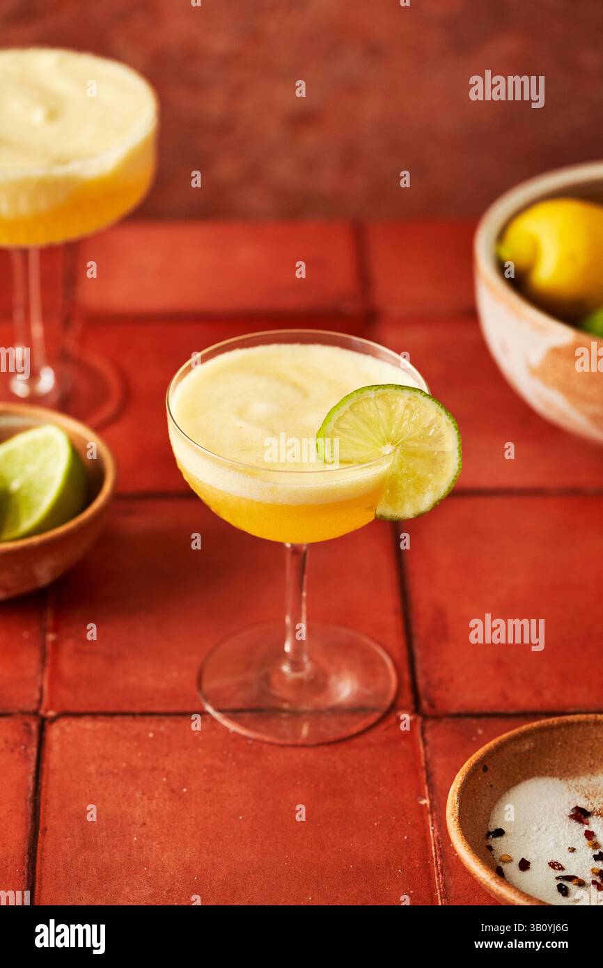 Ananas-Lime-Margarita auf Terrakottafliesen-Oberfläche mit Chili-gesalzenem Rand Stockfoto