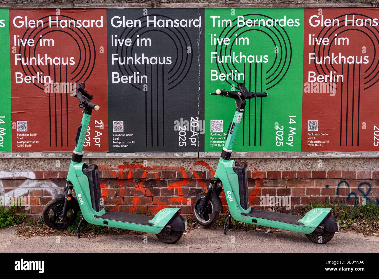 Elektische Schritte. Zwei elektrische Stufen parkten an einer Ziegelmauer und warteten darauf, dass der nächste Fahrer sie mietet. Berlin, Deutschland. Berlin - Lichtenberg Funkhaus Berlin Deutschland Copyright: XGuidoxKoppesxPhotox Stockfoto