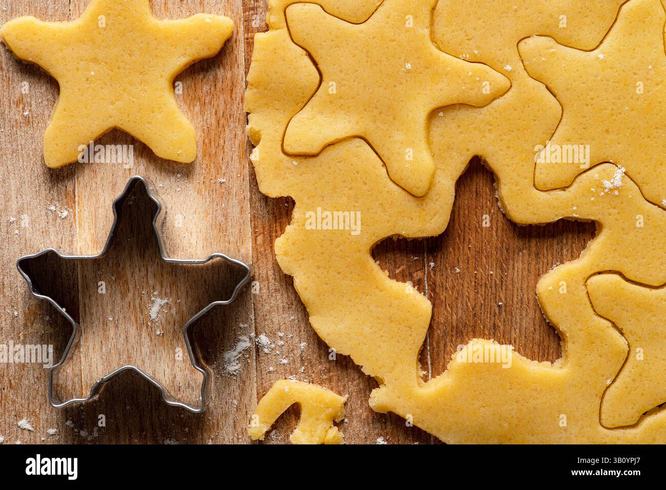 Die rohen Shortbread Biscuits und der ausgerollte Shortcrust-Teig werden auf ein hölzernes Schneidebrett gelegt. Draufsicht. Stockfoto