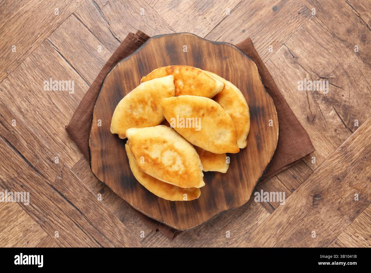 Köstliche gebratene Pyrizhky (gefüllte Kuchen) auf Holztisch, Blick von oben Stockfoto Köstliche gebratene Pyrizhky (gefüllte Kuchen) auf Holztisch, Blick von oben Stockfoto