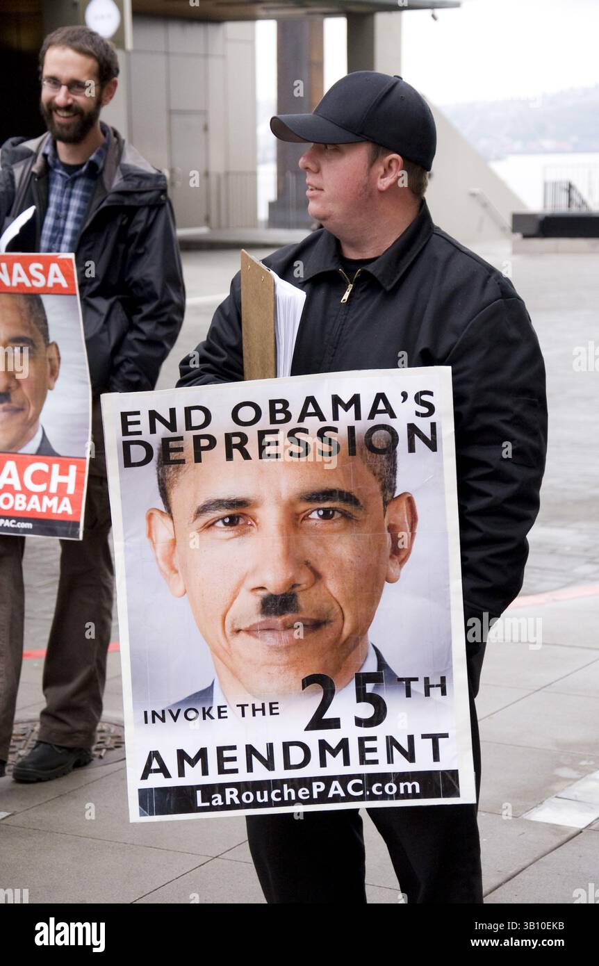 6. November 2010: Seattle, Washington, USA: Lyndon LaRouche-Unterstützer auf der 1st Avenue in Seattle, WA, mit Plakaten von US-Präsident Obama mit Hitler-Schnurrbart. Lyndon LaRouche kündigte kürzlich an, dass er die sofortige Amtsenthebung von Präsident Obama gefordert habe und behauptete, er sei offensichtlich nicht mehr geistig kompetent, um im Vorsitz zu bleiben. LaRouche verlangte die Berufung auf den 25. Zusatzartikel, der die geordnete Absetzung eines Präsidenten vorsieht, und dessen Ersatz durch den Vizepräsidenten aufgrund körperlicher oder geistiger Beeinträchtigungen. Ironischerweise betrachten viele Kritiker LaRouche als Faschis Stockfoto
