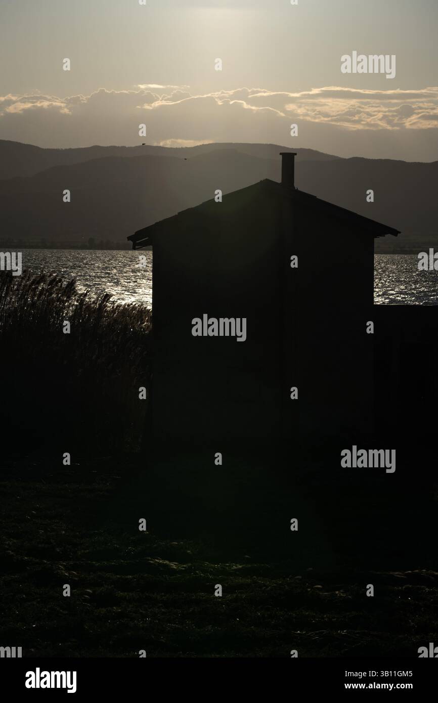 Silhouetted Awakening: Haus am Morning Lake Stockfoto