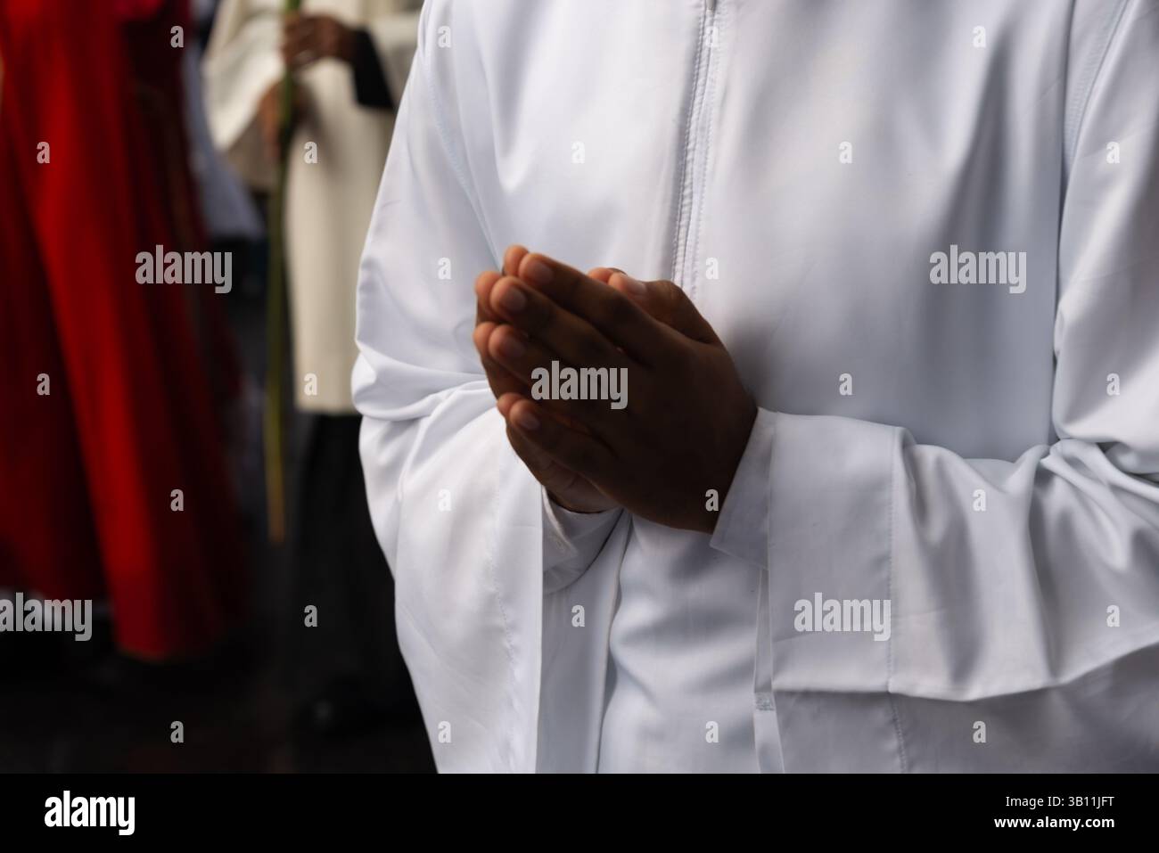 Priester und Seminaristen werden während einer Palmsonntagsprozession in Salvador, Brasilien, beim Spaziergang beobachtet. Stockfoto