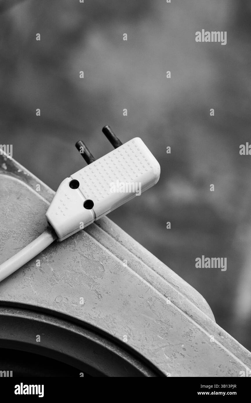 Künstlerische und klare Darstellung eines elektrischen Kabels und Steckers, erfasst im mittleren Rahmen mit geringer Schärfentiefe. Hervorragend geeignet für Themen wie Energie zu Hause, Elektro Stockfoto