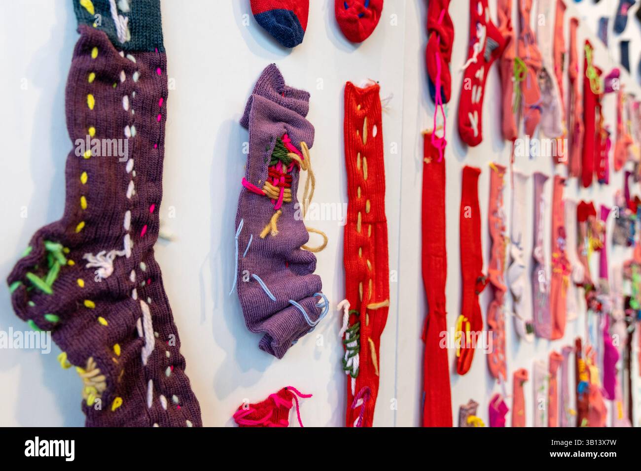 Januar 2025: Ausstellung „Socks: The Art of Care and Repair“ von Celia Pym in der NOW Gallery, North Greenwich, London, England Stockfoto
