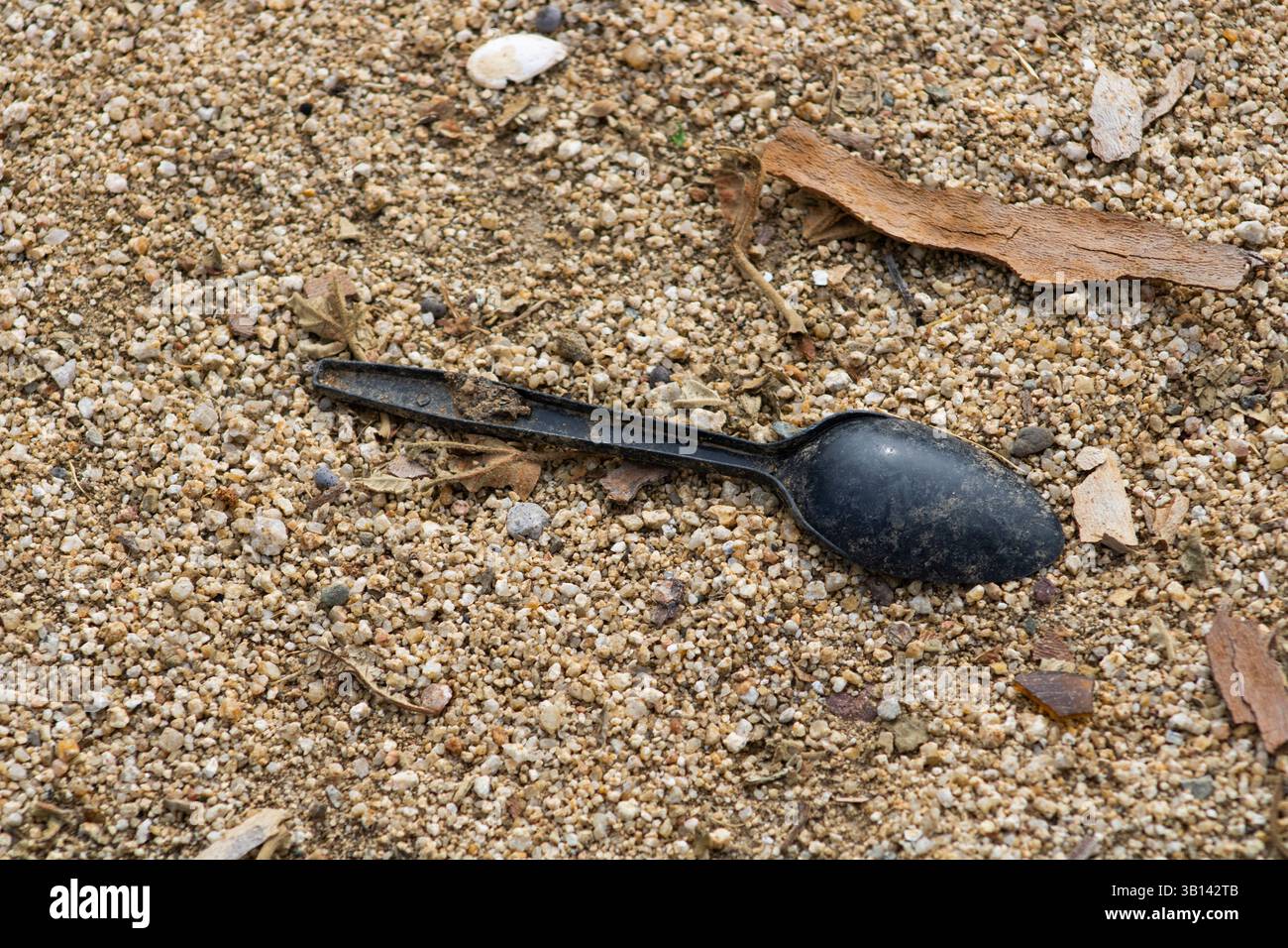 Schwarzes Löffelutensil in Schmutz Stockfoto