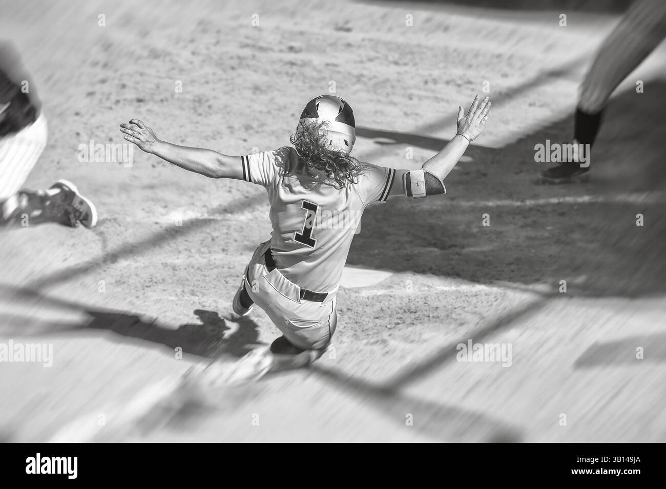 Ein Softball-Baseballspieler schlüpft in die Home Plate Schwarz und weiß Stockfoto