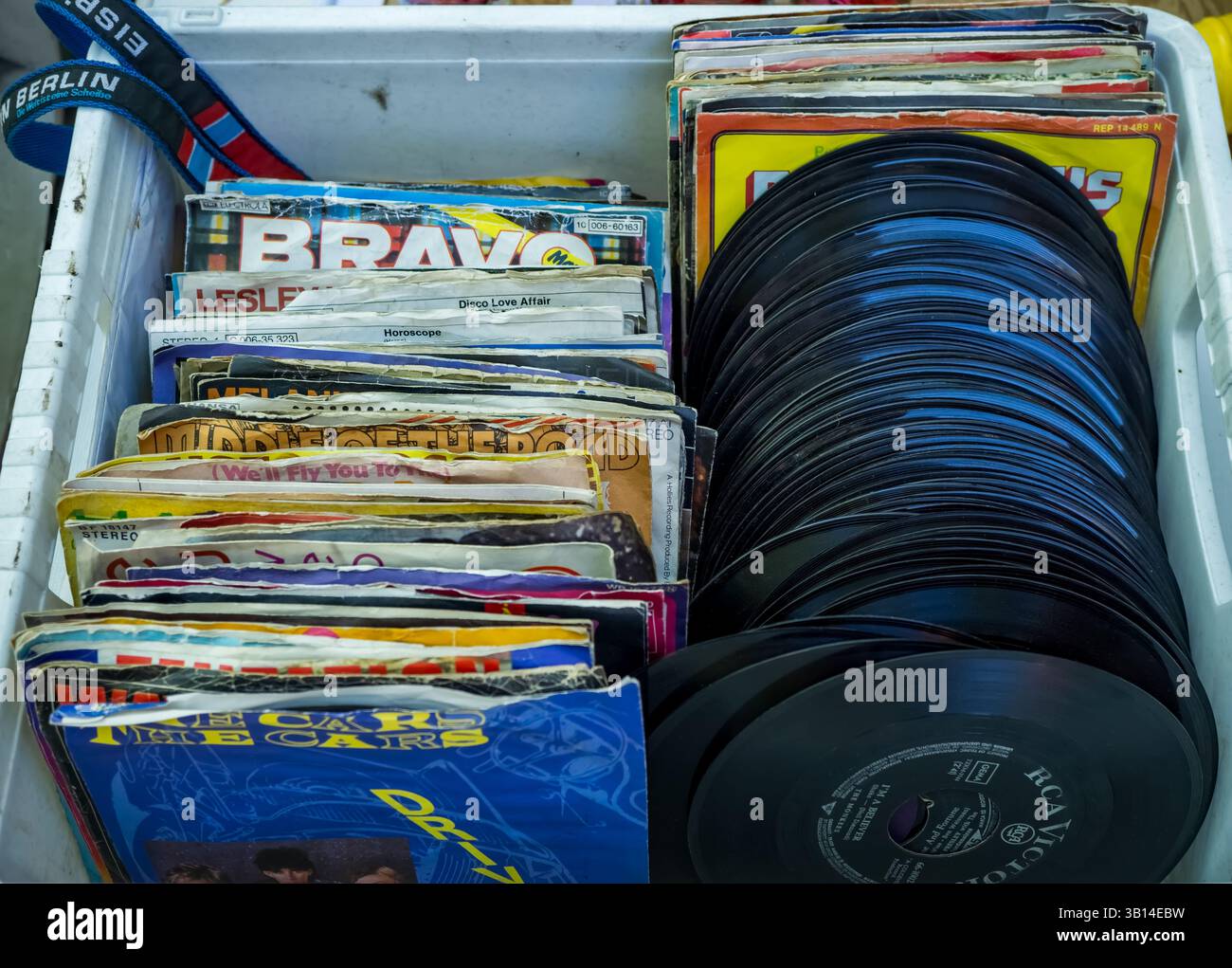 Vintage-Schallplatten in einer Kiste auf einem Berliner Flohmarkt, bunte alte Ärmel und klassische Alben für Sammler und Musikliebhaber. Stockfoto