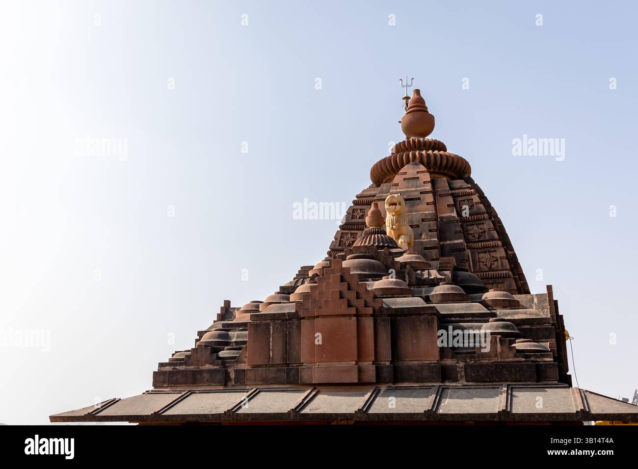 Antike Hindutempelarchitektur mit Löwenidol und shiva Trident am Tag Stockfoto