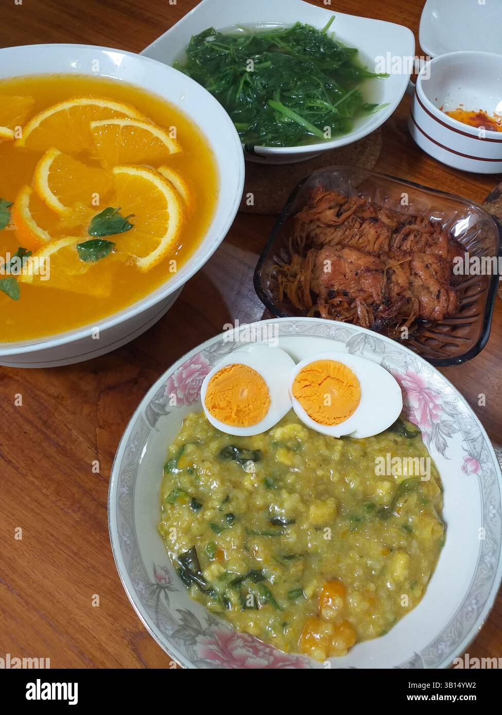 Bubur manado oder Tinutuan Brei, traditioneller Brei. Manadonesischer Reisbrei, gemischt mit Kürbis, Mais, Gemüse. Serviert mit gesalzenem Tofu-Fisch. Stockfoto