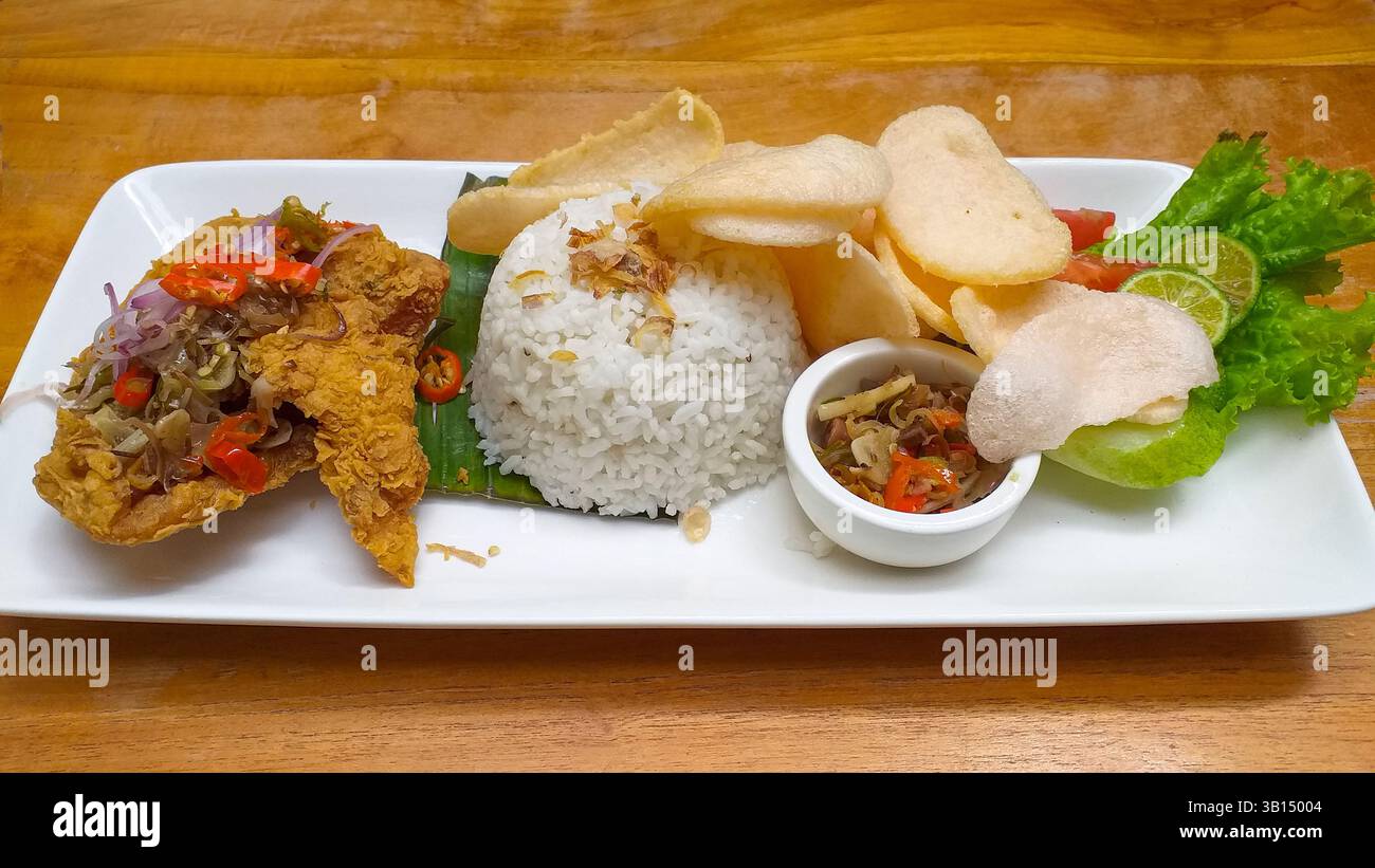 Nasi Ayam Goreng, indonesisches Essen mit scharfem Sambal Matah. Stockfoto
