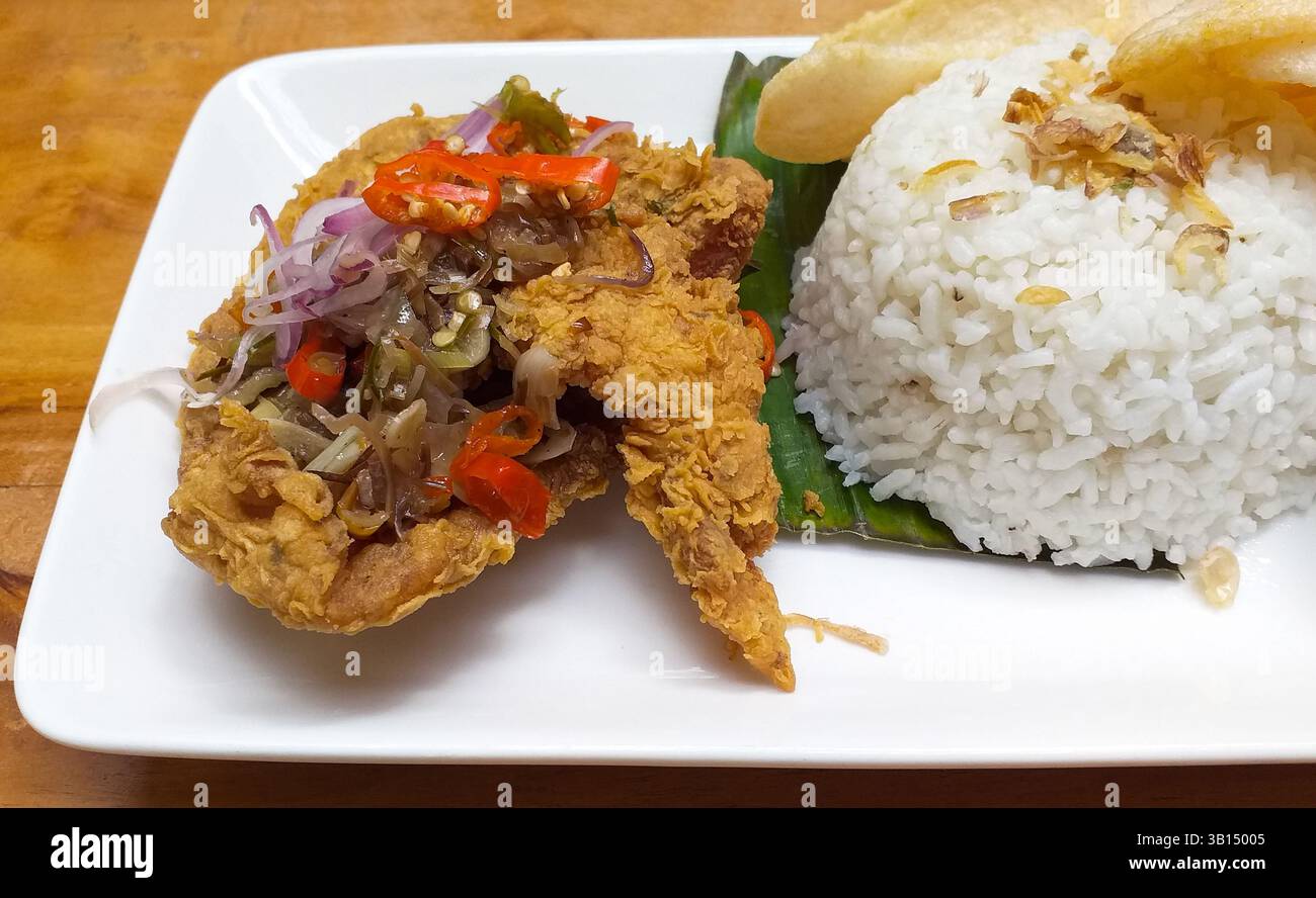 Nasi Ayam Goreng, indonesisches Essen mit scharfem Sambal Matah. Stockfoto