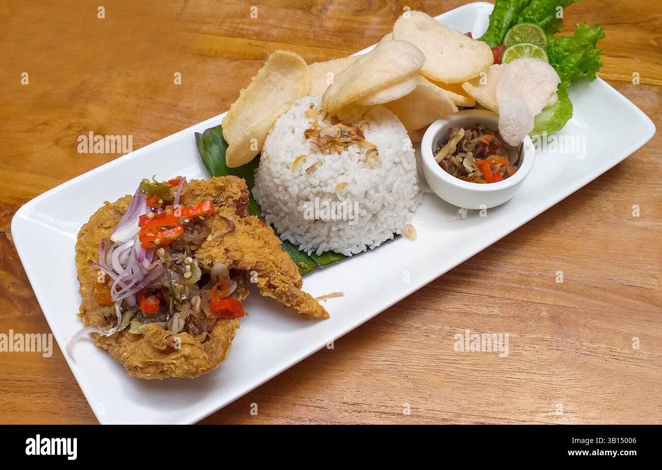 Nasi Ayam Goreng, indonesisches Essen mit scharfem Sambal Matah. Stockfoto