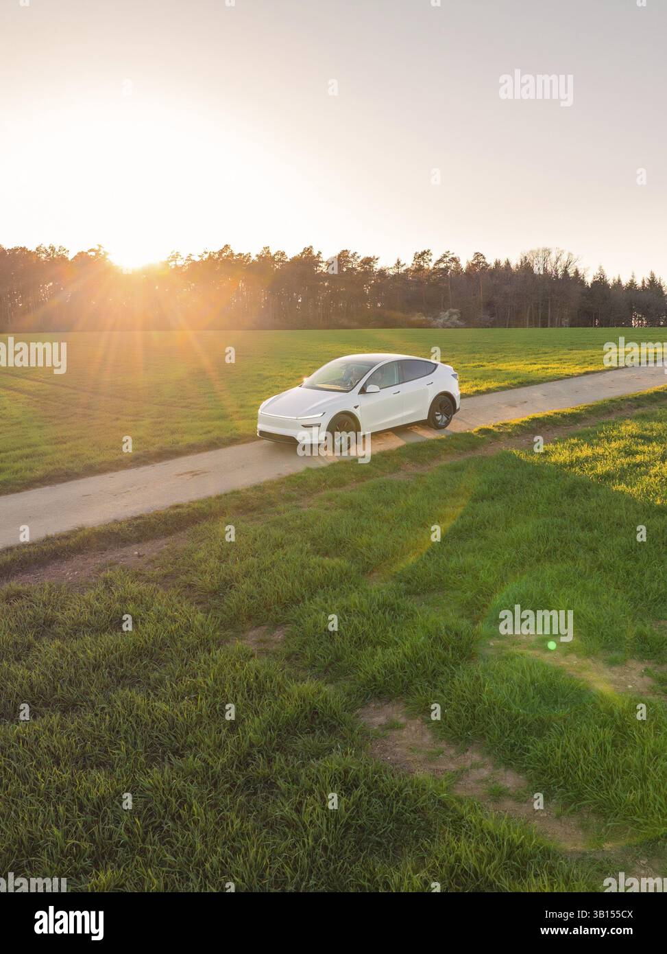 Ein weißes Auto fährt in einer idyllischen ländlichen Gegend im Licht des Sonnenuntergangs, Tesla, New Model Y, Schwarzwald, Deutschland, Europa Stockfoto