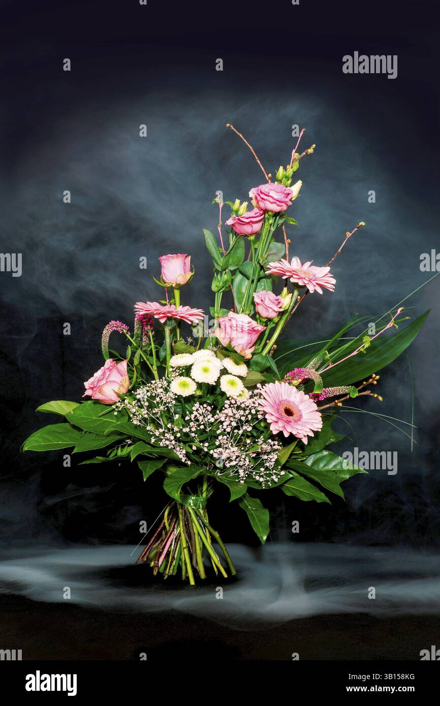 Farbenfroher Blumenstrauß auf schwarzem Hintergrund mit Nebeleffekt Stockfoto