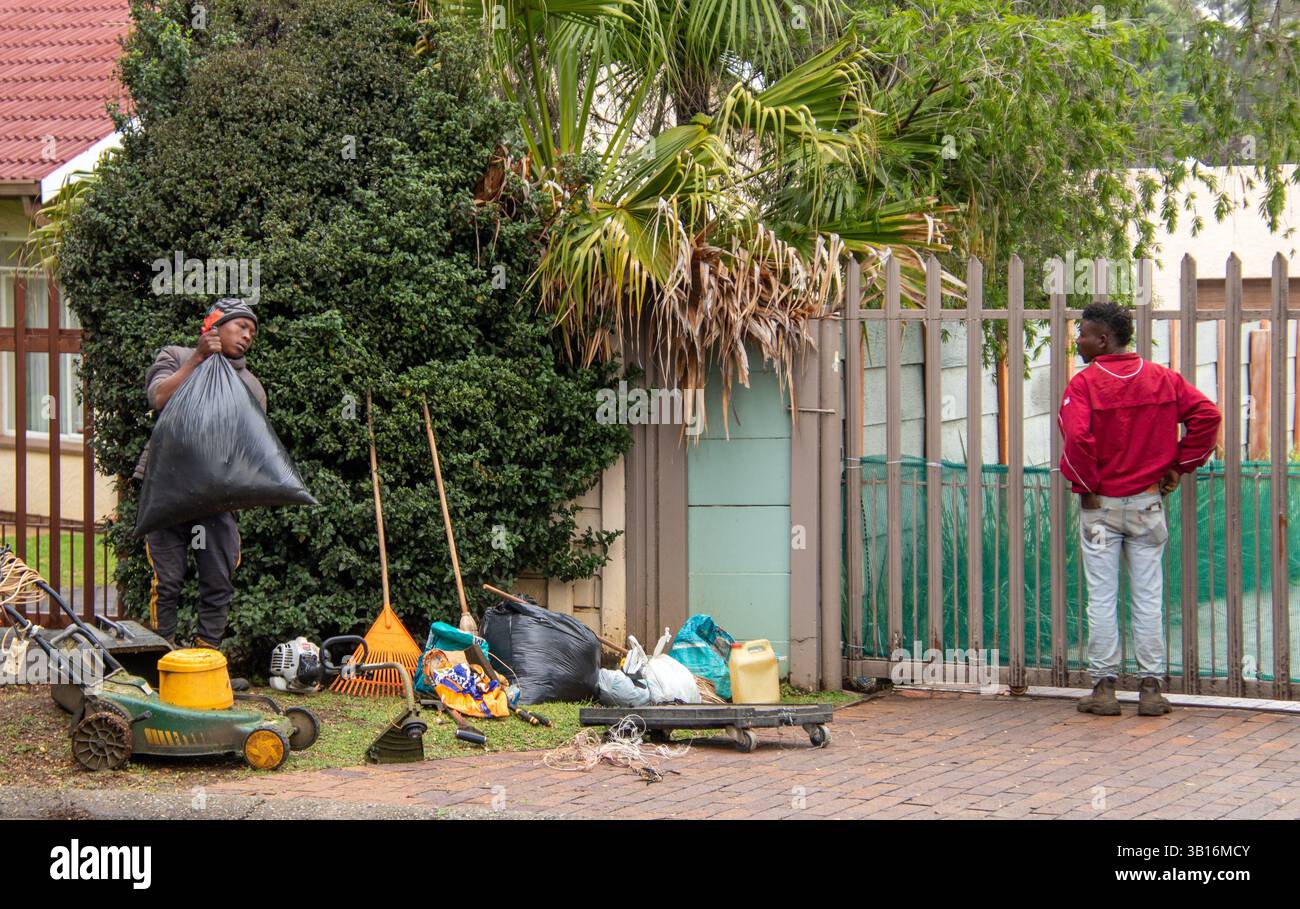 Johannesburg, Südafrika - zwei nicht identifizierte junge Arbeiter bieten mobilen Gartenreinigungsservice für Haushalte in der Stadt an Stockfoto