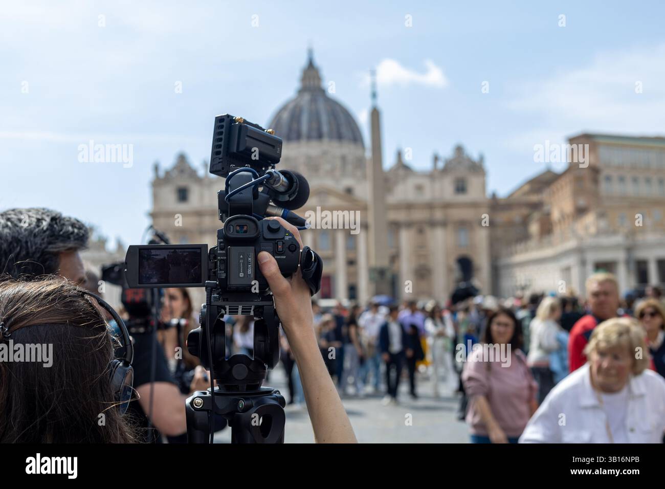 Vatikan - 23. April 2025: Professionelle Kamerafilme mit Basilika und Menschenmenge im Hintergrund. Stockfoto