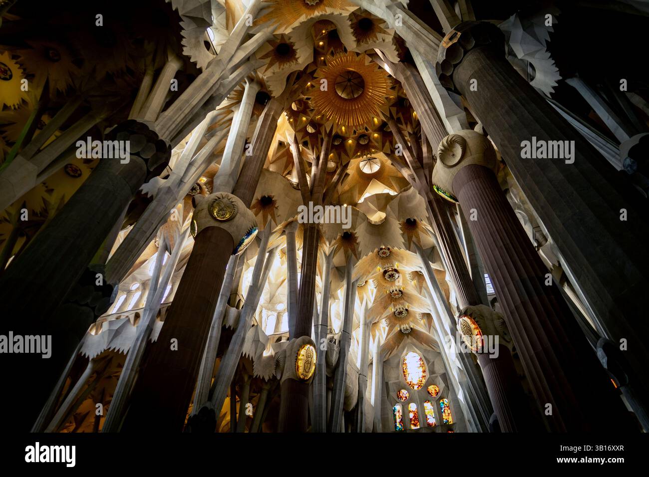 Ein atemberaubender Innenblick auf eine große Kathedrale mit hohen, aufwändig gestalteten Säulen und einer Decke mit kunstvollen Mustern und goldenen Elemen Stockfoto