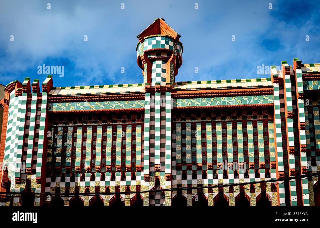 Eine farbenfrohe architektonische Fassade mit einer Mischung aus grünen, weißen und rosa karierten Mustern, mit einem Turm an der Spitze. Das Gebäude zeigt eine faszinierende Erscheinung Stockfoto
