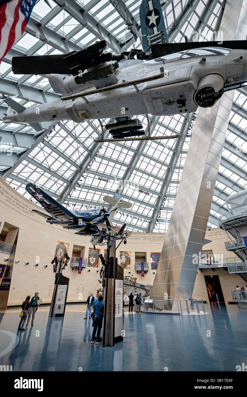 TRIANGLE, Virginia, USA – das hoch aufragende Atrium, bekannt als Leatherneck Gallery, dient als zentraler Raum des National Museum of the Marine Corps. Das 2006 eröffnete Museum verfügt über einen markanten, 210 Meter hohen, geneigten Stahlturm, der das ikonische Bild der Marines weckt, die die Flagge von Iwo Jima hissen. Historische Flugzeuge und große Artefakte hängen in dem dramatischen mehrstöckigen Raum, der Besuchern die Geschichte und das Erbe des Marine Corps näher bringt. Stockfoto