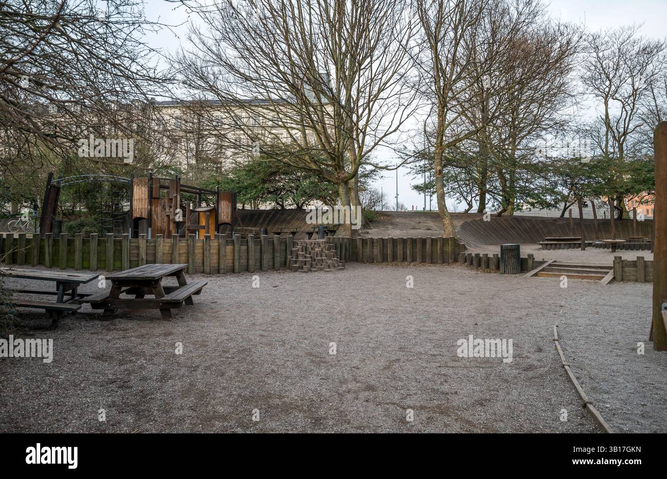 Community Playground in Urban Park umgeben von Bäumen und Holzzaun, Kopenhagen, Dänemark, 16. April 2018 Stockfoto