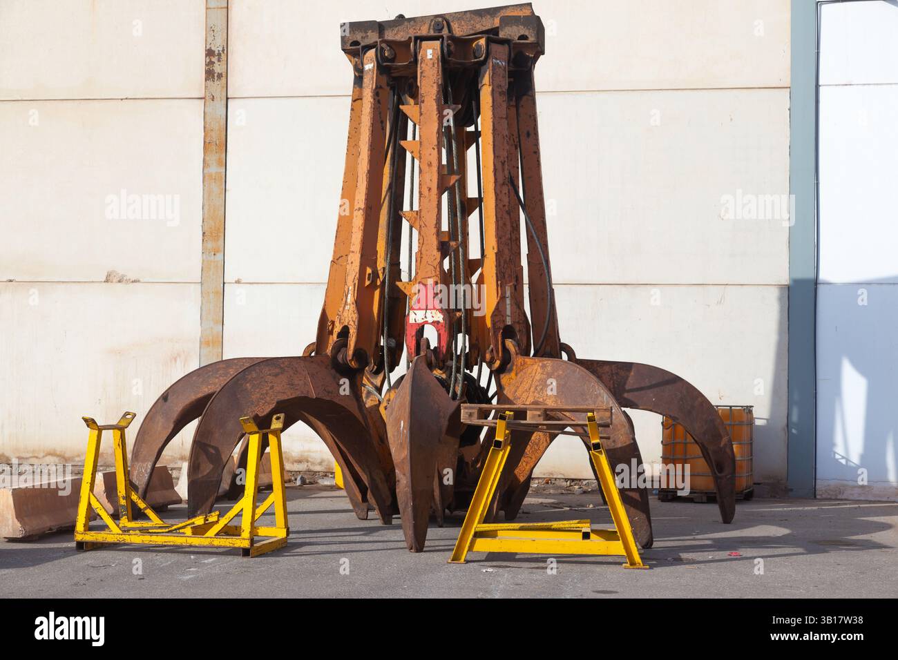 Ein Greifer zum Entladen und Verladen von Metallschrott, der sich auf dem Gebiet befindet. Stockfoto