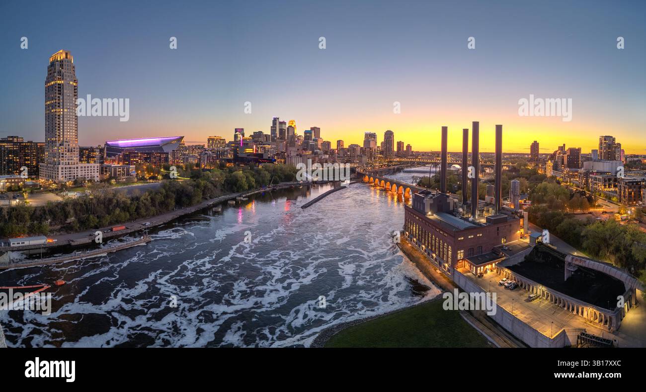 Die Skyline der Innenstadt von Minneapolis, Minnesota, USA über dem Mississippi in der Abenddämmerung. Stockfoto
