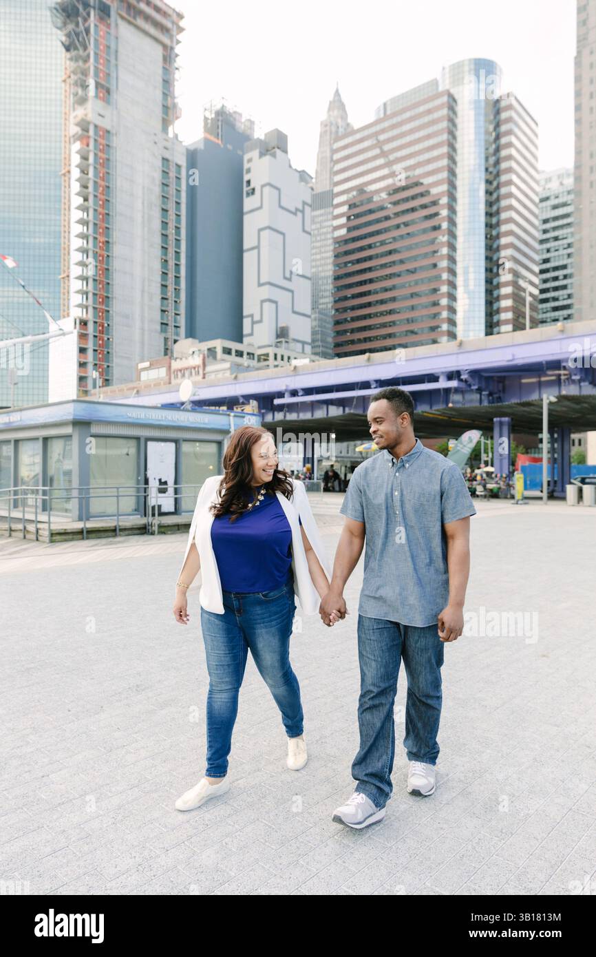 Ein Paar genießt einen gemütlichen Spaziergang durch eine urbane Landschaft am Nachmittag in der Innenstadt Stockfoto
