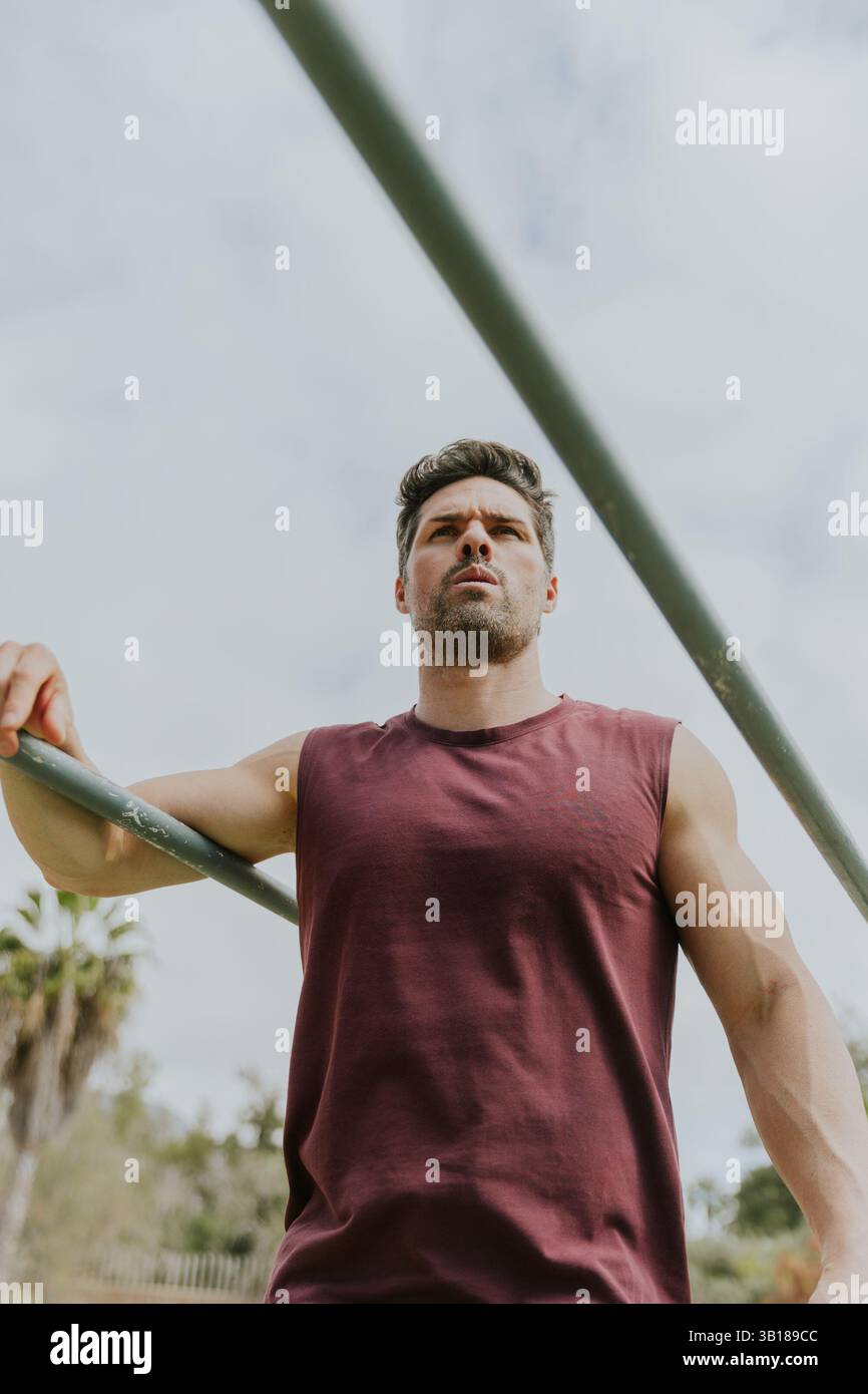 Foto von unten von einem fitten Mann, der in einem Fitnessstudio im Freien trainiert, motiviert und fokussiert. Stockfoto