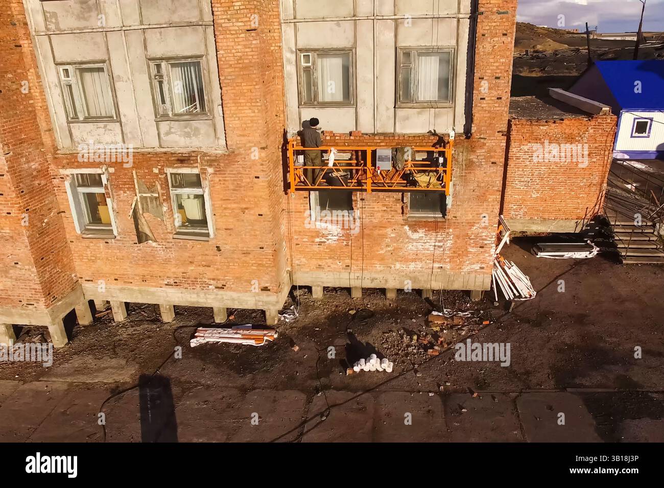 Verstärkung von tragenden Wänden eines Plattenhauses, Verkleidung von Plattenwänden mit Ziegeln. Stockfoto