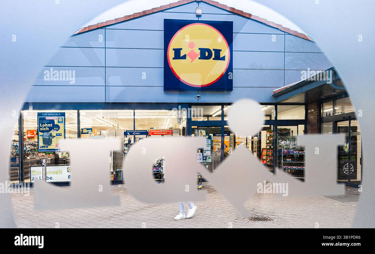 Bargteheide, Deutschland. April 2025. Blick durch eine Fensterscheibe mit dem Lidl-Logo auf die Fassade eines Lidl-Supermarktes mit dem Firmenlogo. Quelle: Markus Scholz/dpa/Alamy Live News Stockfoto