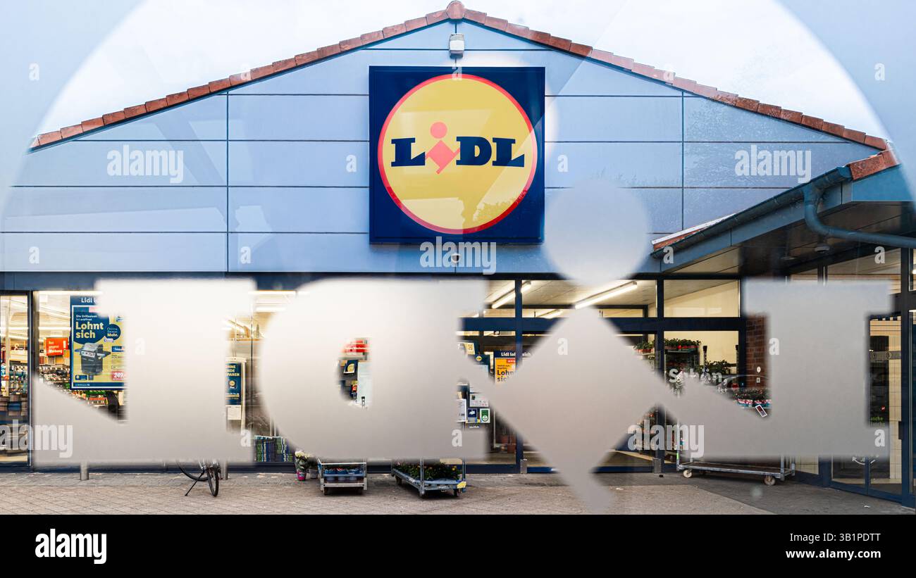 Bargteheide, Deutschland. April 2025. Blick durch eine Fensterscheibe mit dem Lidl-Logo auf die Fassade eines Lidl-Supermarktes mit dem Firmenlogo. Quelle: Markus Scholz/dpa/Alamy Live News Stockfoto