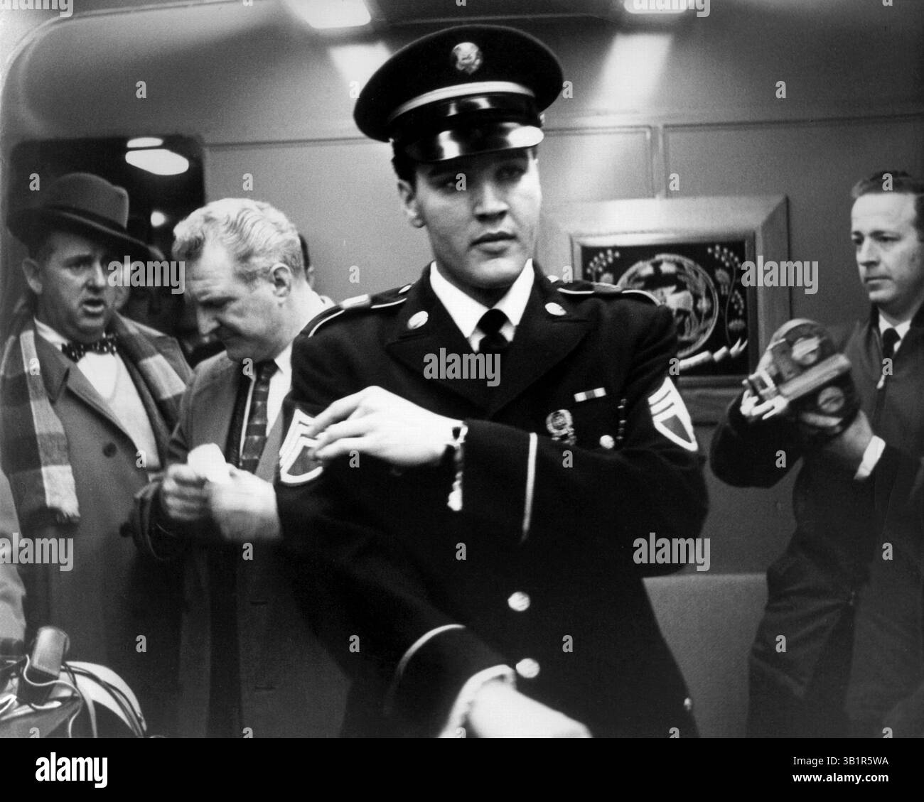 7. März 1960 - Memphis, TN, USA - Elvis Presley an Bord des Zuges, der ihn am 7. März 1960 nach Memphis brachte. Rund 200 Fans warteten auf der Union Station, um ihn von seinem Aufenthalt in der US Army zu Hause zu begrüßen. Elvis trug eine (nicht-Ausgabe) blaue Uniform der Armee, die er in Deutschland gemacht hatte. Der Schneider gab ihm fälschlicherweise die Streifen eines Stab-Sergeants und nicht eines Sergeants, in dem er entlassen wurde. Das formelle weiße Hemd war ein Geschenk von Frank Sinatra, das seine Tochter Nancy an Elvis’ erstem Tag zurück in den USA am vergangenen Donnerstag (3. März) überbrachte. Am 2. März Stockfoto