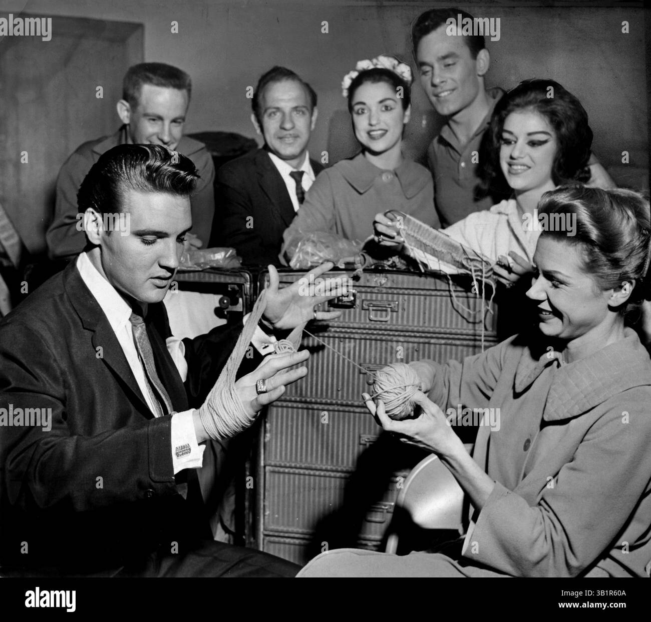 9. März 1962 - Memphis, TN, USA - Elvis Presley ging in der Nacht des 9. März 1962 hinter die Kulissen im Auditorium, um einige seiner Freunde in der Holiday on Ice Cast begrüßen zu lassen, und Skating-Star Dorothy Goos brachte ihn sofort mit Garn an die Arbeit. Elvis hatte während ihrer letzten drei jährlichen Besuche die Holiday on Ice People hier besucht. (Kreditbild: © The Commercial Appeal/ZUMApress.com) Stockfoto 9. März 1962 - Memphis, TN, USA - Elvis Presley ging in der Nacht des 9. März 1962 hinter die Kulissen im Auditorium, um einige seiner Freunde in der Holiday on Ice Cast begrüßen zu lassen, und Skating-Star Dorothy Goos brachte ihn sofort mit Garn an die Arbeit. Elvis hatte während ihrer letzten drei jährlichen Besuche die Holiday on Ice People hier besucht. (Kreditbild: © The Commercial Appeal/ZUMApress.com) Stockfoto