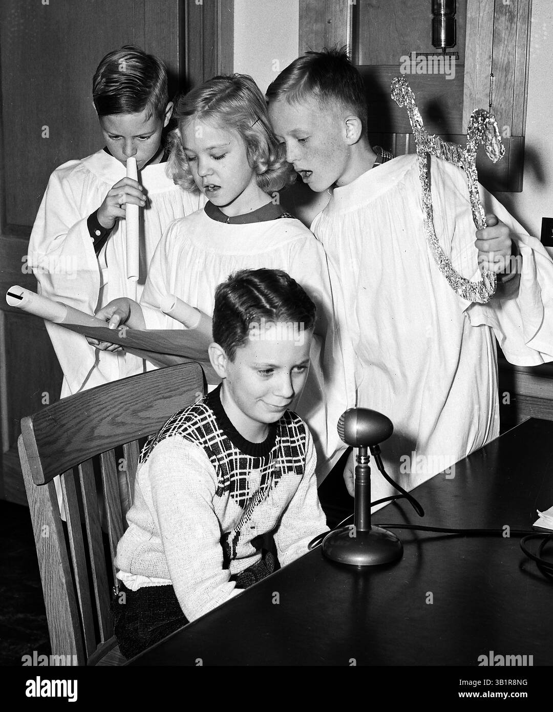 13. Dezember 1950 – Memphis, TN, USA – JIMMY JALENAK (sitzend) erklärt seinen Mitschülern an der East High die Bedeutung des Weihnachtssiegelverkaufs zur Bekämpfung der Tuberkulose am 13. Dezember 1950. Der Verkauf der Robben ist in den Schulen im Gange. Die Engel, die auf den diesjährigen Robben abgebildet sind, sind (von links) LEE PARCHMAN, HARRIET SIKES und BLAIR MEREDITH. (Kreditbild: © The Commercial Appeal/ZUMApress.com) Stockfoto