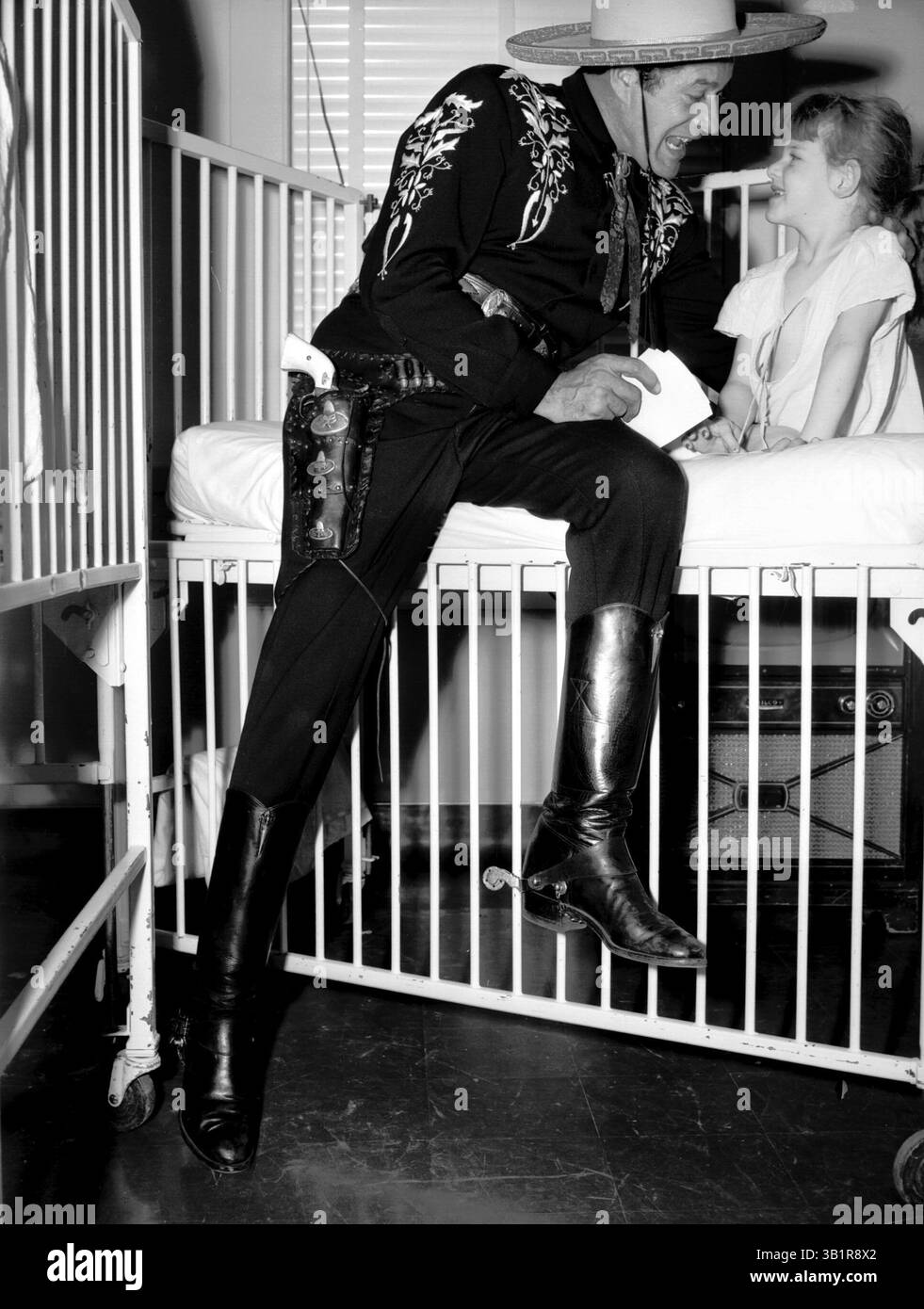 1. Oktober 1954 - Memphis, TN, USA - HI SENORITA - so spricht CISCO KID, einer der beliebtesten Cowboys im Fernsehen, die 4-jährige Charlotte Byrd aus Holly Springs, Miss. Im Crippled Children's Hospital, bei einem Besuch in Memphis Ende September 1954. The Kid, eine beliebte Attraktion auf der WMCT, erschien am 1. Oktober auf der Mid-South Fair. (Kreditbild: © The Commercial Appeal/ZUMApress.com) Stockfoto