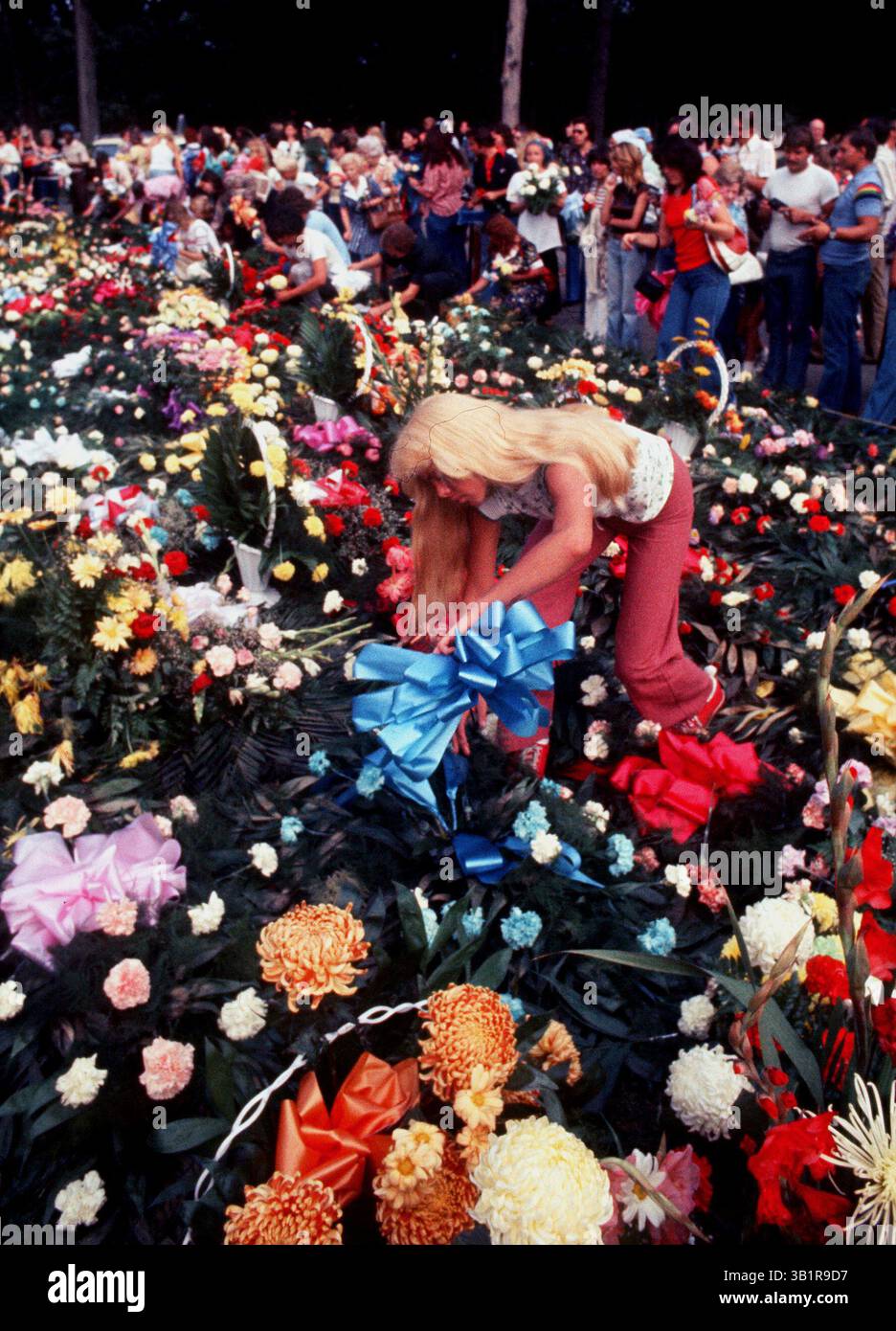 August 1977 - Memphis, TN, USA - Forest Hill Cemetery Midtown 19. August 1977. Mehr als 50.000 Fans, von denen einige eine nächtliche Mahnwache an den Toren des Friedhofs hielten, gingen die letzte Meile, um Elvis Presley Tribut zu zollen, und gingen mit den Blumen, die sein Mausoleum am Hügel säumten. Mehr als 3.000 Blumenarrangements wurden auf dem Mausoleum-Rasen verteilt. (Kreditbild: © The Commercial Appeal/ZUMApress.com) Stockfoto August 1977 - Memphis, TN, USA - Forest Hill Cemetery Midtown 19. August 1977. Mehr als 50.000 Fans, von denen einige eine nächtliche Mahnwache an den Toren des Friedhofs hielten, gingen die letzte Meile, um Elvis Presley Tribut zu zollen, und gingen mit den Blumen, die sein Mausoleum am Hügel säumten. Mehr als 3.000 Blumenarrangements wurden auf dem Mausoleum-Rasen verteilt. (Kreditbild: © The Commercial Appeal/ZUMApress.com) Stockfoto