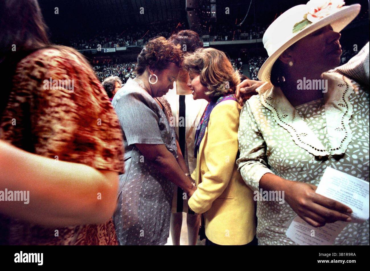 30. März 1997: Memphis, TN, USA: Valerie Moore (Mitte links) und Nancy Lubiani beten gemeinsam beim Ostergottesdienst Love Thy Neighbor in der Pyramide in Memphis am 30. März 1997. Etwa 16.000 Menschen nahmen an dem Gottesdienst Teil, eine gemeinsame Anstrengung der überwiegend schwarzen Mississippi Boulevard Christian Church und der überwiegend weißen Christ United Methodist Church, um die Rassen zum Gottesdienst zusammenzubringen. (Kreditbild: © The Commercial Appeal/ZUMApress.com) Stockfoto