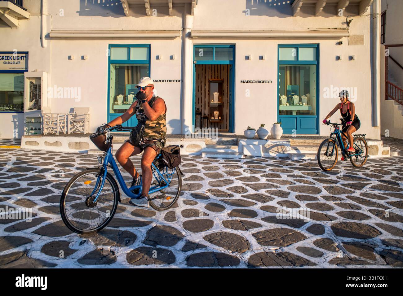 Entdecken Sie Mykonos in einem Fahrradverleih, Mykonos Uferpromenade und Stadtlandschaft bei Sonnenuntergang, Kykladen, Griechenland. Mykonos ist eine griechische Insel, die zum CYCL gehört Stockfoto