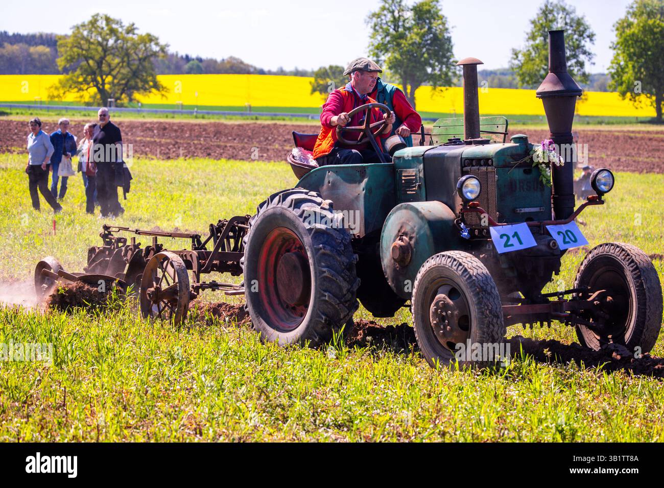 Goddin, Deutschland. April 2025. Sven und Wilfried Baumert brechen den Boden mit einem Ursus C45-Traktor auf, der 1947 beim 22. Westmecklenburgischen Pflügerwettbewerb gebaut wurde. Historische Traktoren fahren beim Pflügen von Oldtimer-Traktoren über ein Feld, während moderne Teams beim Wettbewerb nebenan Zentimetergenau Furchen pflügen, beobachtet von mehr als 1.000 Besuchern. Quelle: Jens Büttner/dpa/Alamy Live News Stockfoto