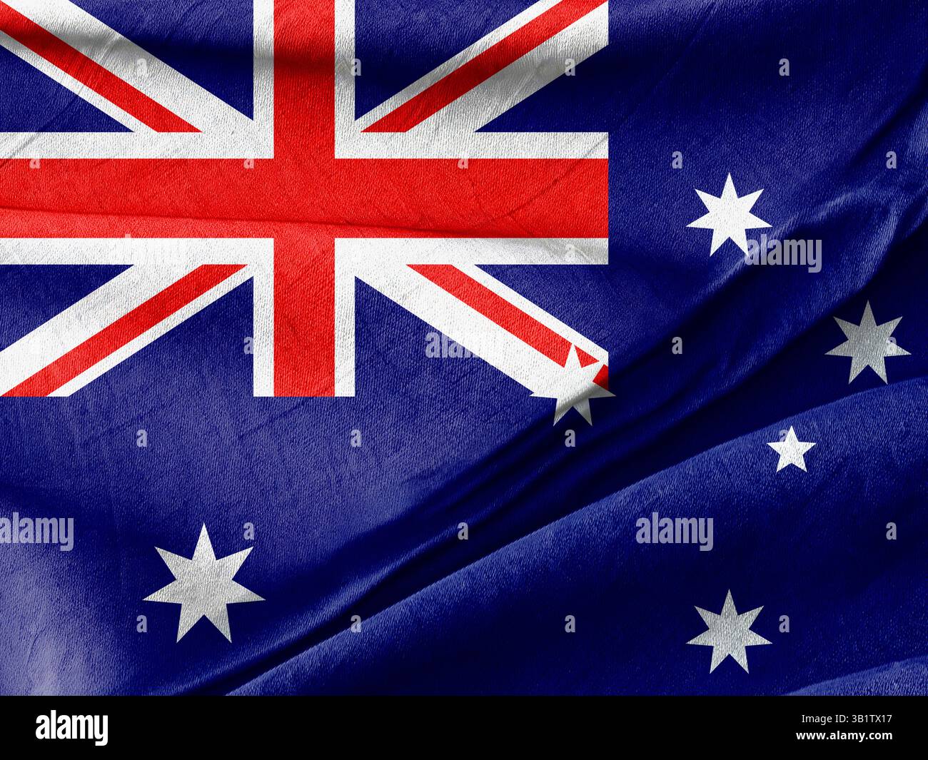 Das Bild zeigt die australische Flagge, die Muster, Farben und Textur mit Falten betont, die das Material des Stoffes verstärken und die Nationalflagge symbolisieren Stockfoto