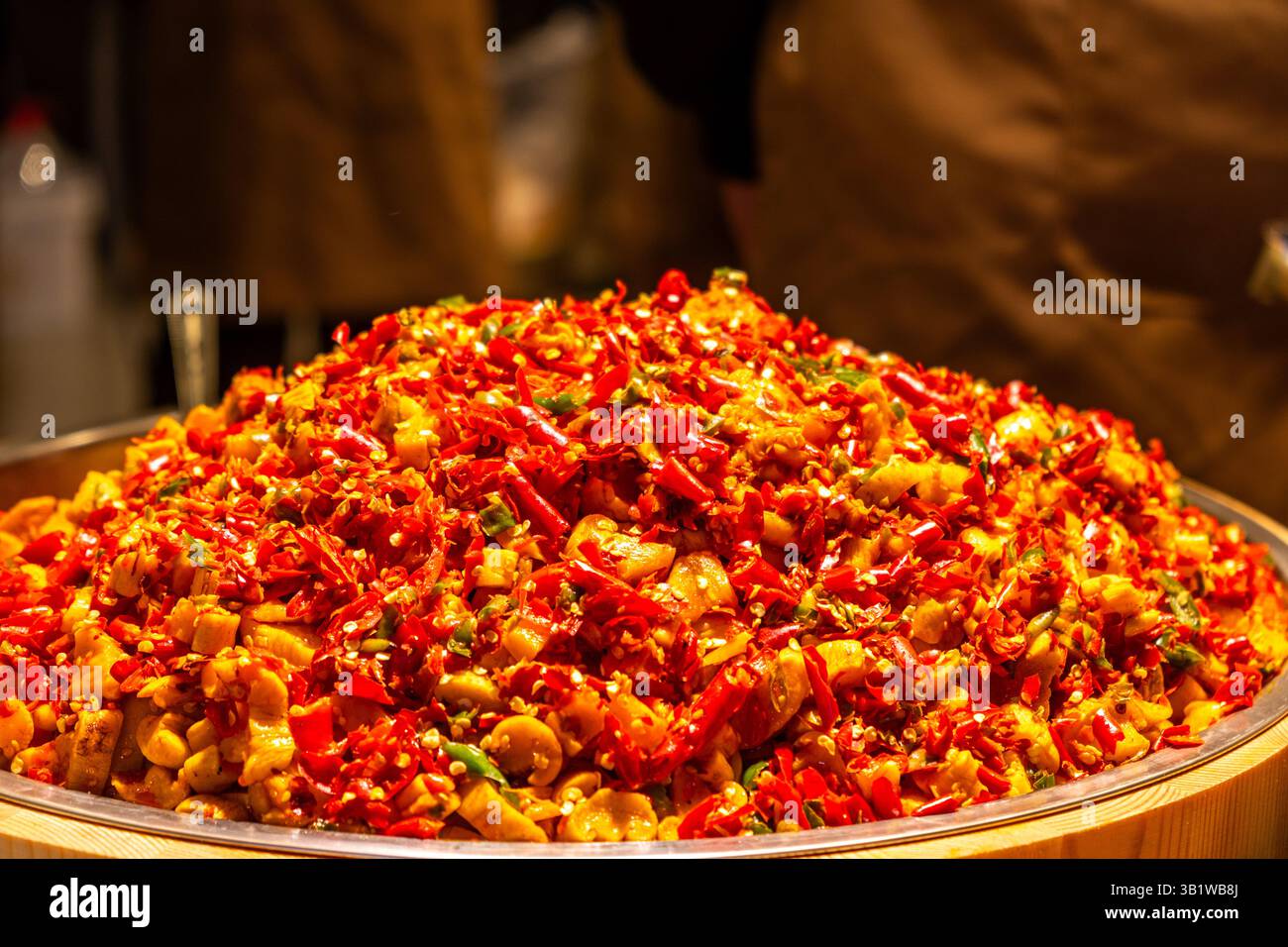 Chinesisches Straßenessen, scharfe gebratene Chili-Paprika aus der Nähe. Gehacktes Gemüse und Fleischstücke, Sichuan-Küche. Stockfoto