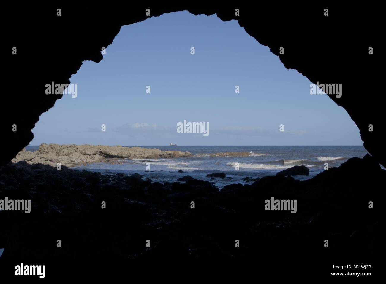 Blick auf das Meer durch den Eingang einer felsigen Meereshöhle an der Küste. Seaham Beach, England Stockfoto