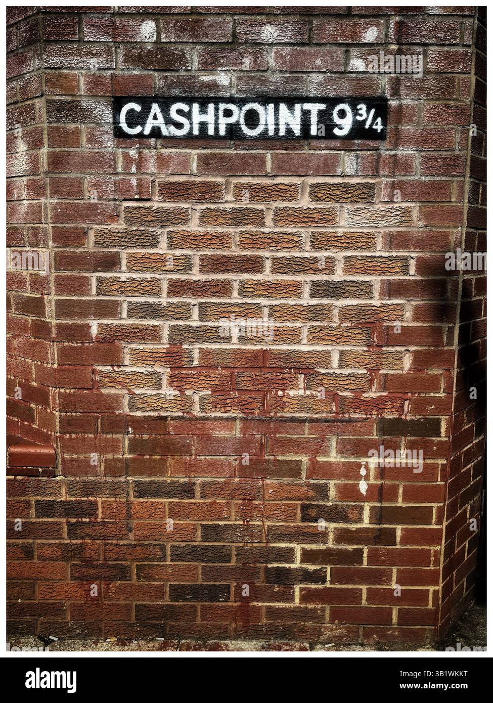 Ein gemauerter Geldpunkt mit einer humorvollen Referenz auf die unsichtbare Plattform 9 3/4 von Harry Potter, die in weißer Farbe darüber schabloniert ist Stockfoto