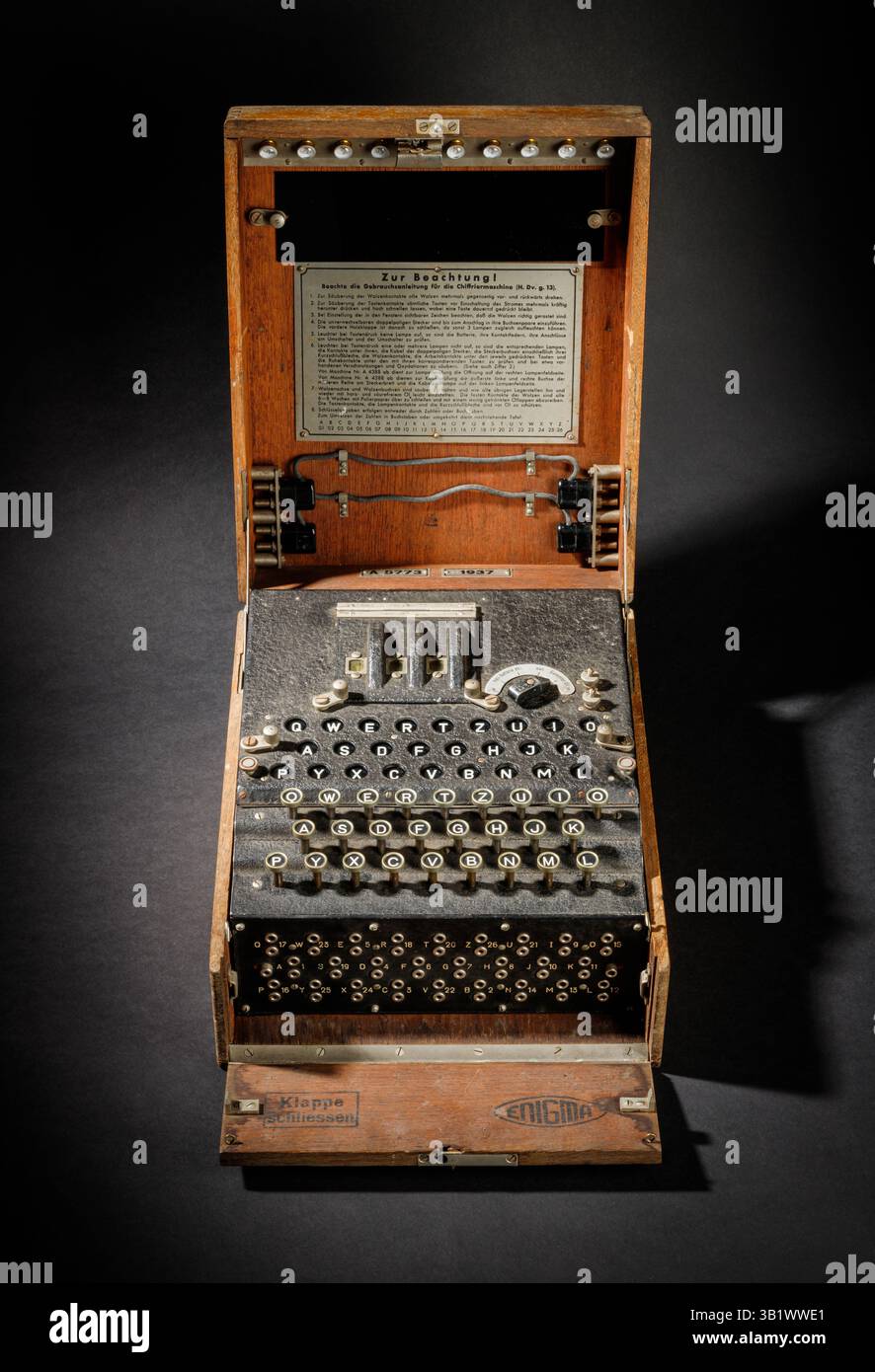 Historische Enigma-Maschine Schreibmaschine mit Tastatur als Symbol für Verschlüsselung, Rätsel und geheime Kommunikation im technologischen Wandel - auf dunklem Rücken Stockfoto