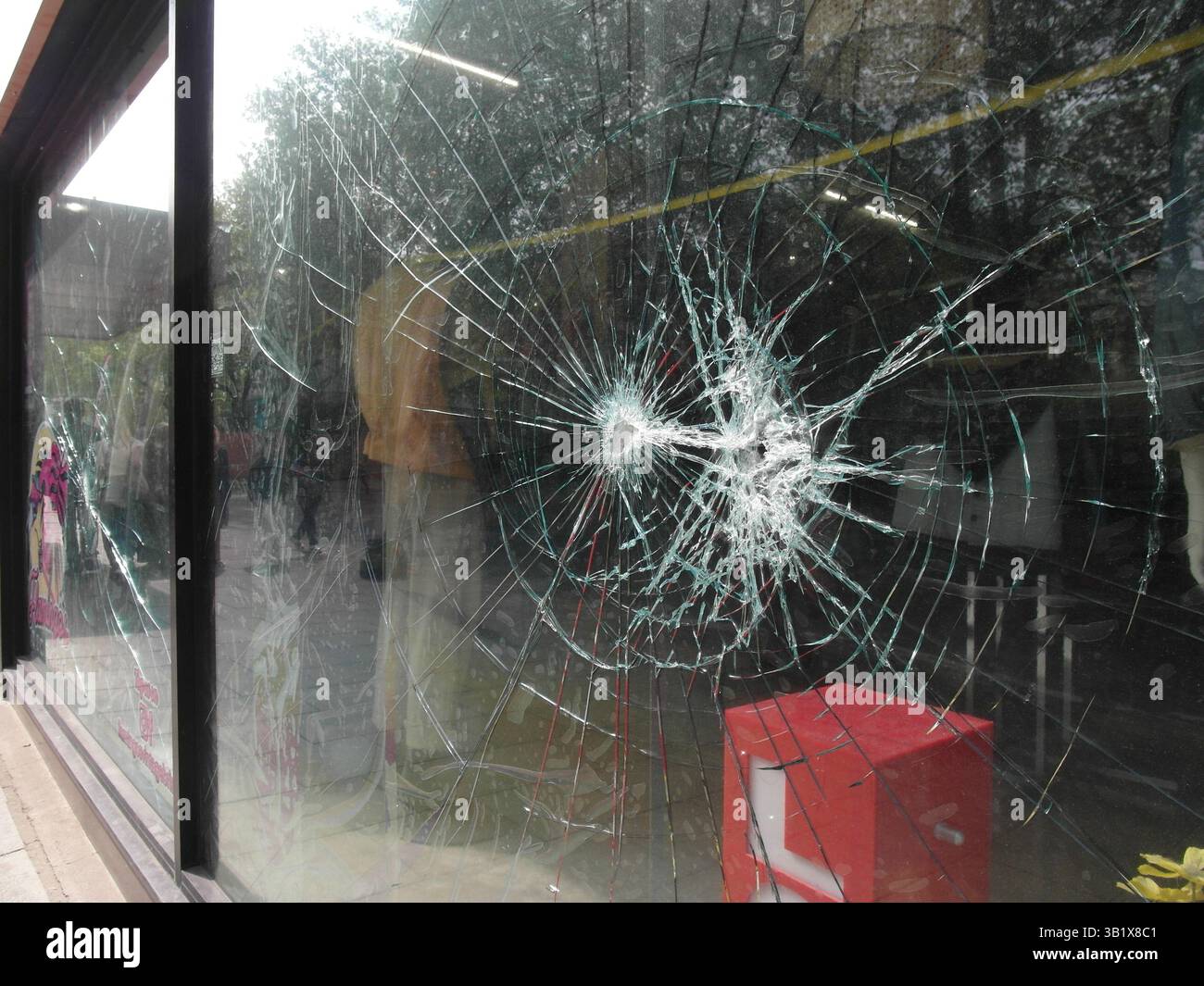 Beschädigtes, zertrümmertes Schaufenster im Stadtzentrum, möglicherweise durch Vandalismus und antisoziales Verhalten. Bristol, Großbritannien Stockfoto