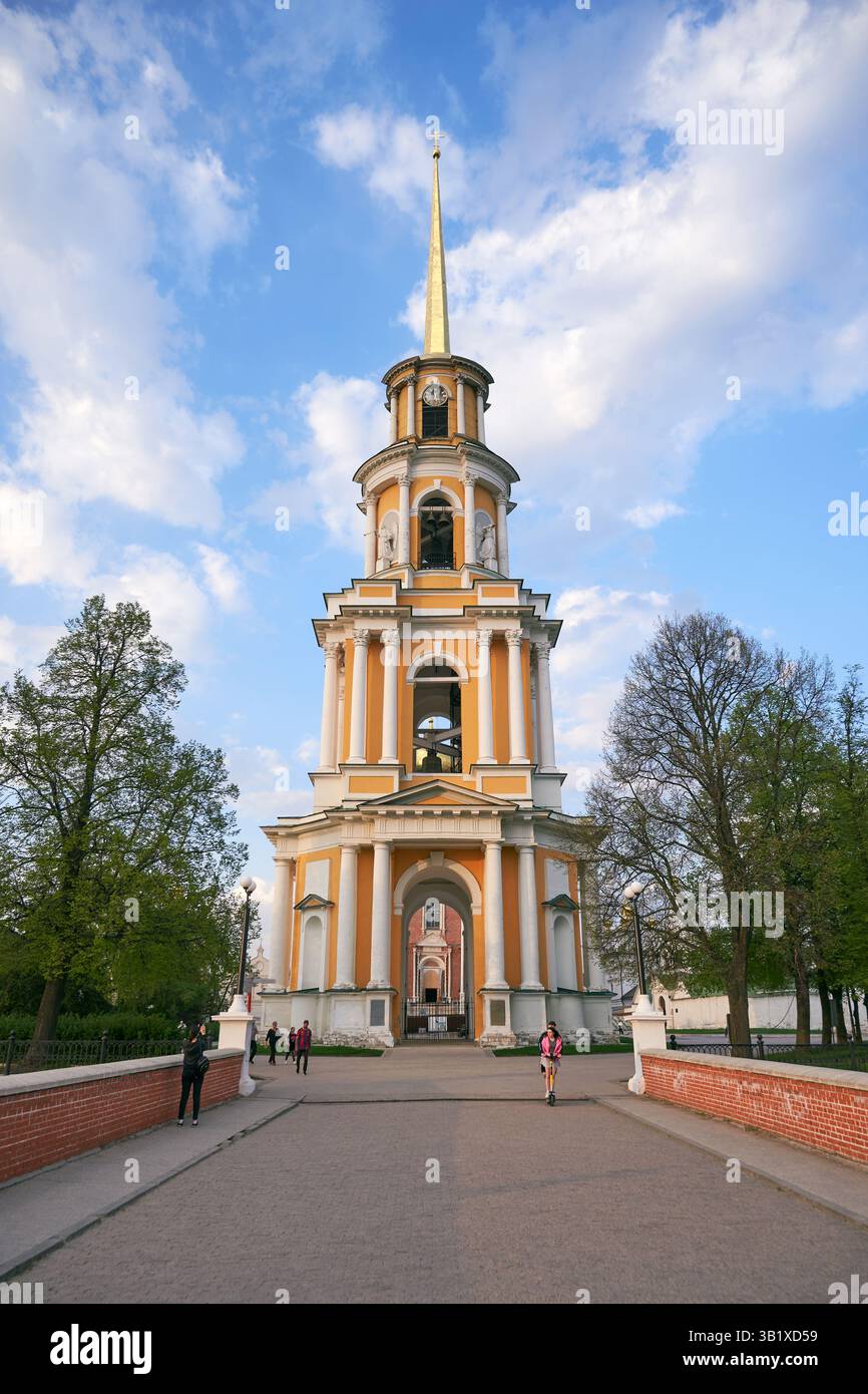 Ein hoher alter Glockenturm vor einem blauen Himmel mit weißen Wolken Stockfoto