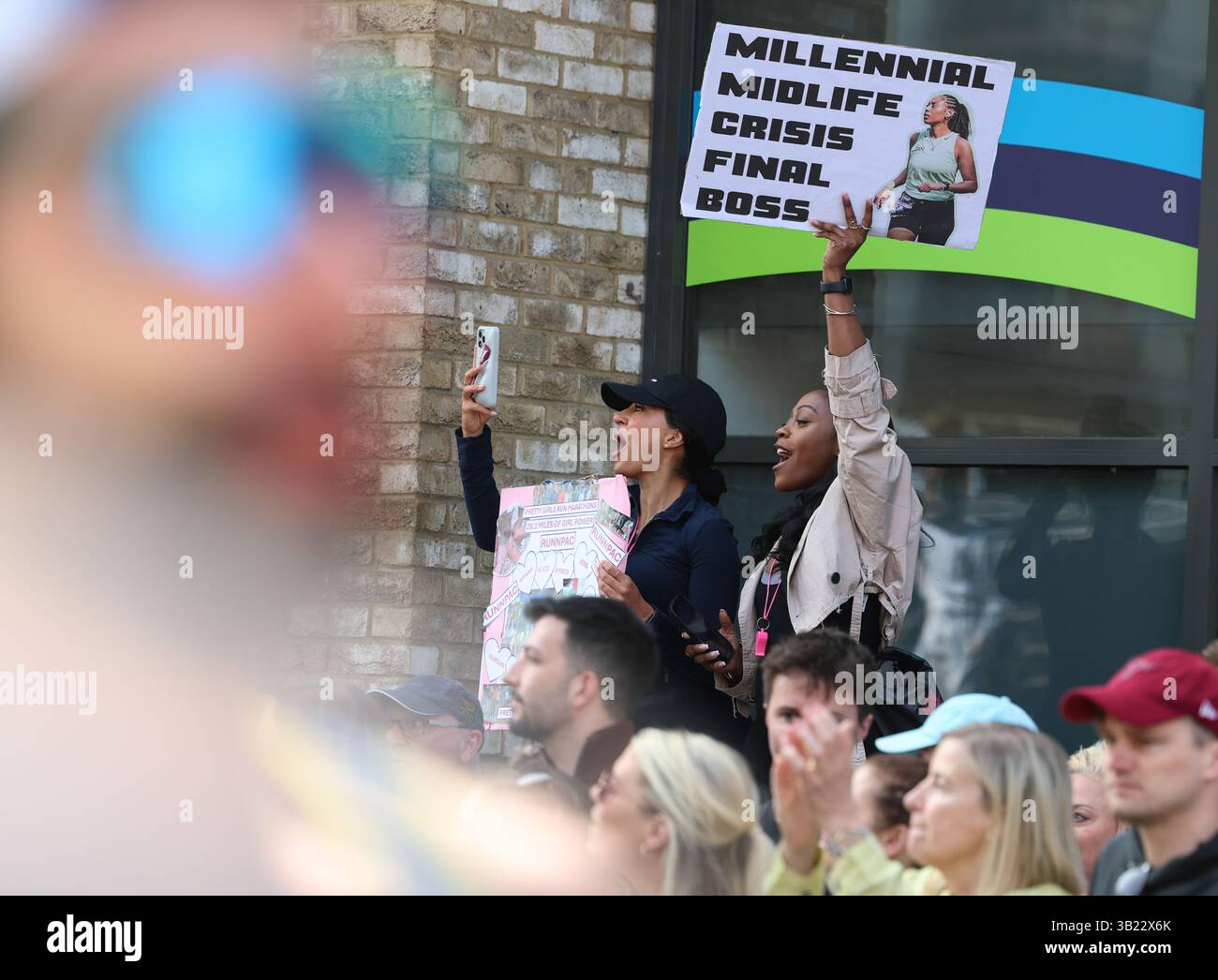London, Großbritannien. April 2025. A Supporters halten ein Banner „Millenial Midlufe Crisis Final Boss“ als Motivation beim TCS London Marathon 2025 während des TCS London Marathon am 27. April 2025 in London, England, Großbritannien Credit: Andrew Sumner/Alamy Live News Stockfoto