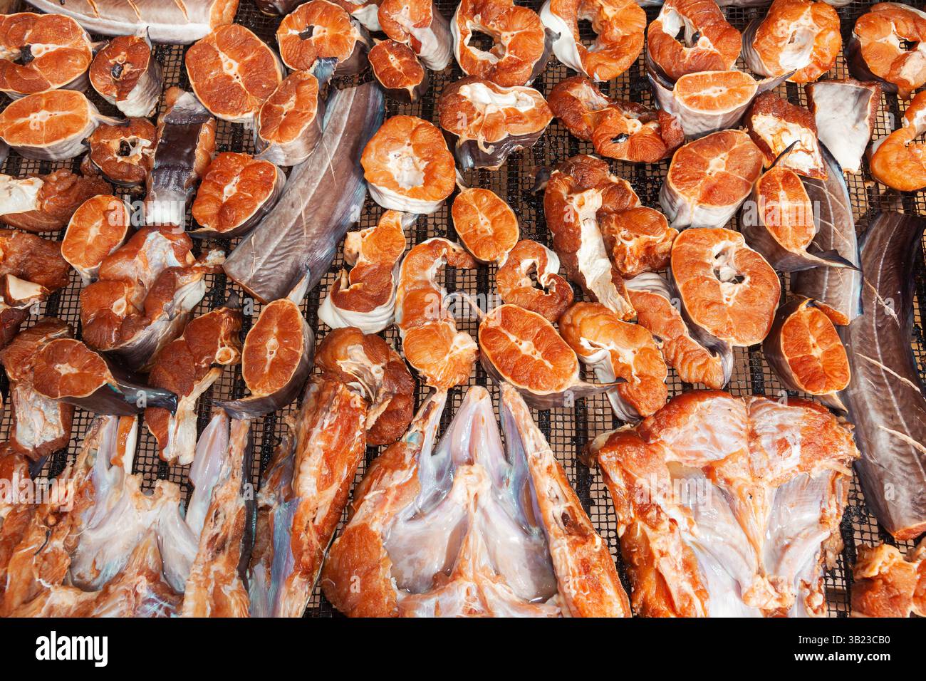 Frische Fischstücke werden auf einem Stahlgitter getrocknet. Stockfoto