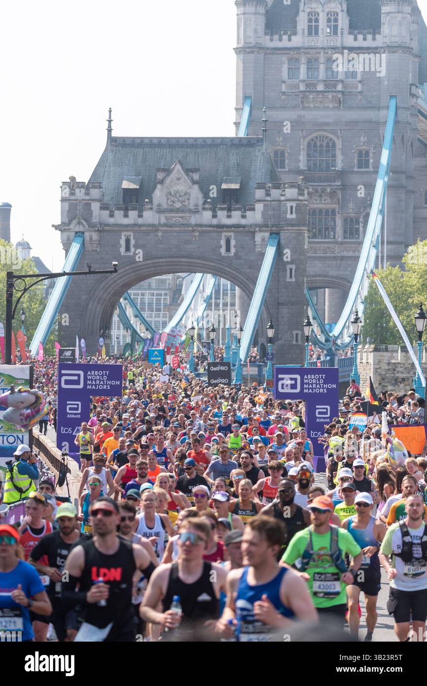 Tower Hill, London, Großbritannien. April 2025. Rund 56.000 Menschen nehmen am TCS London Marathon 2025 Teil, darunter die weltbesten Elite-Läufer und Rollstuhlsportler. Die Massen von Club- und Fun-Läufern folgen ihnen, wobei viele große Summen für wohltätige Zwecke sammeln. Massen überqueren die Tower Bridge Stockfoto